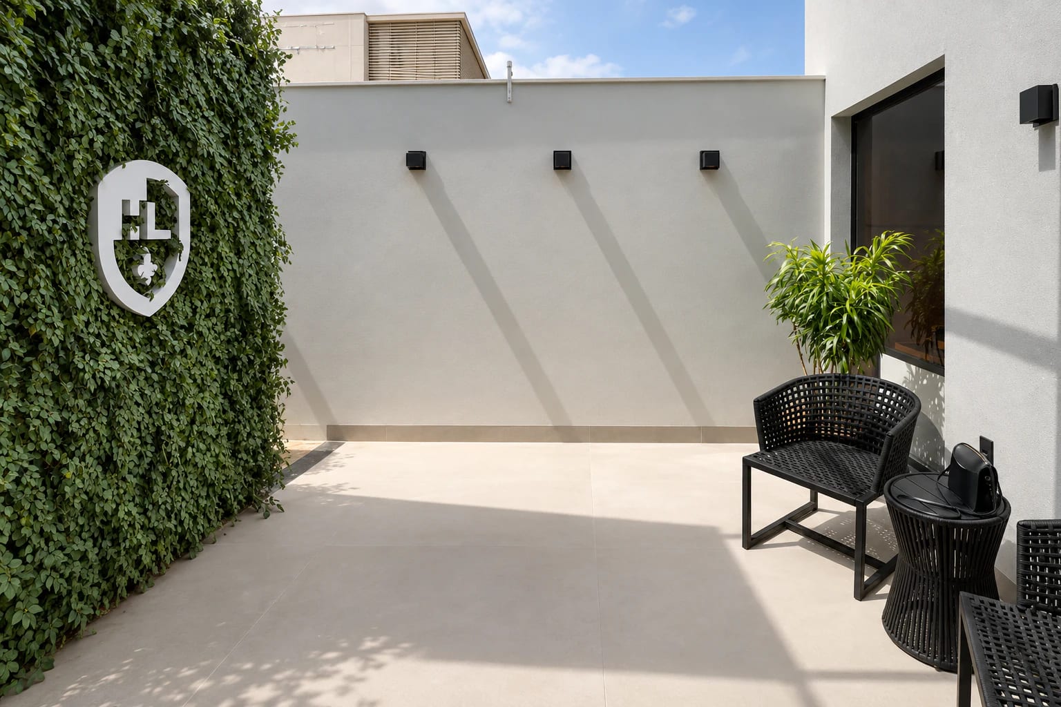 Pátio interno da unidade de Irecê, com o brasão sobre um jardim vertical.